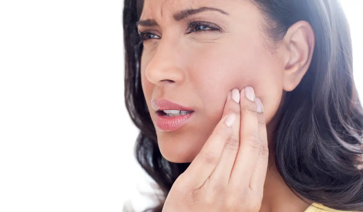 Woman with jaw pain showing signs of TMJ disorder and facial muscle tension discomfort.