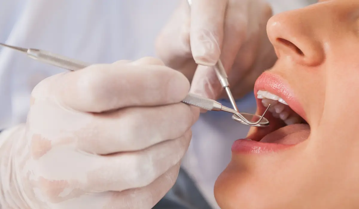 Close-up of dentist examining gum tissue to detect early signs of inflammation affecting overall health.
